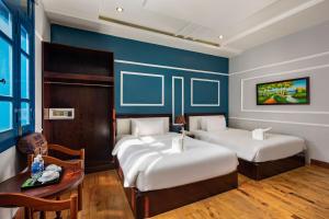 a hotel room with two beds and a table at Sofia Boutique Hotel in Danang