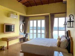 a bedroom with a bed and a desk with a television at Vera Costa Hotel in Nong Khai