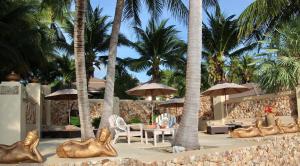 a resort with palm trees and tables and gold animals at Sibaja Palms Sunset Beach Luxury Apartments in Taling Ngam Beach