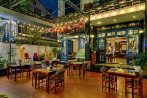 a restaurant with tables and chairs in front of a building at Sofia Boutique Hotel in Danang
