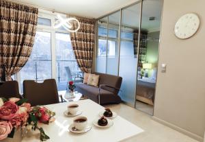 - un salon avec une table fleurie et une horloge dans l'établissement Apartament Szyndzielnia, à Bielsko-Biała