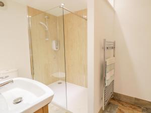 ein Badezimmer mit Dusche und Waschbecken in der Unterkunft Plas Tirion Cottage in Mostyn + 13 Fotos