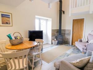 a living room with a table and a fireplace at Plas Tirion Cottage in Mostyn