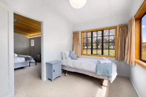a bedroom with two beds and a window at Wanaka Stone Cottage - Wanaka Holiday Home in Wanaka