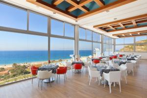 uma sala com mesas e cadeiras e o oceano em Atrium Platinum Resort & Spa em Ixia