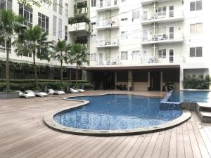 a swimming pool in front of a building at Channel Stay @ Bogor Icon Apartment in Bogor