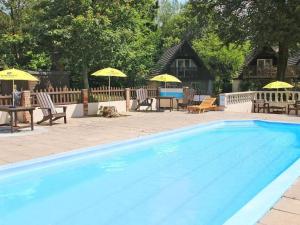 una gran piscina con mesas, sillas y sombrillas en Dartmoor Valley Lodge, en Gunnislake