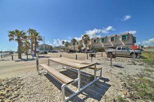 a wooden bench sitting on the side of a beach at Coastal Studio with Amenities Walk to Padre Beach! in Corpus Christi