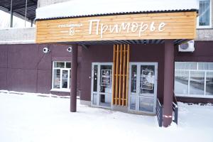 ノヴォシビルスクにあるPrimorye Hotelの雪面の看板をつけた店舗