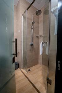 baño con cabina de ducha con puerta de cristal en Hotel Sanchaung en Yangón