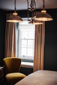 a dining room with a table and a chair and a window at Blonde Hedgehog in Alderney