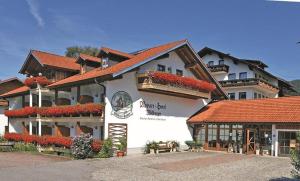 a large white building with flowers in front of it at Appart-Hotel Wildererstuben in Bodenmais