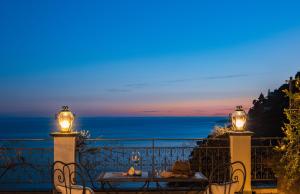 un tavolo e sedie su un balcone con vista sull'oceano di Positano Art Hotel Pasitea a Positano