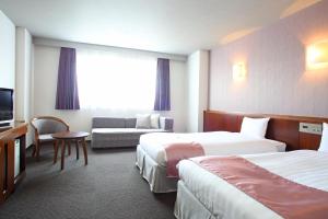 浦安市にあるSPA&HOTEL舞浜ユーラシアのベッド2台とソファが備わるホテルルームです。