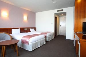 um quarto de hotel com duas camas e uma televisão em SPA&HOTEL EURASIA MAIHAMA em Urayasu