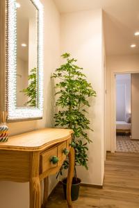 een badkamer met een houten tafel en een plant naast een spiegel bij Dimora Labbate in Polignano a Mare
