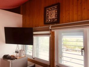 Sala de estar con 2 ventanas y TV en 睡海邊-小木屋 en Suao