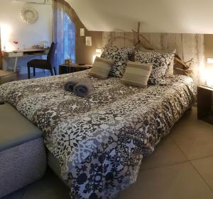 a bedroom with a bed with a black and white comforter at La Villa Esterel & SPA in Village-Neuf