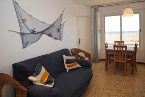 ein Wohnzimmer mit einem blauen Sofa und einem Tisch in der Unterkunft AT076 Baix a Mar in Torredembarra