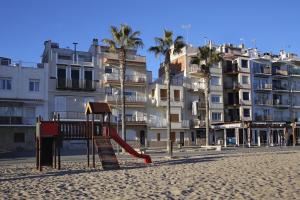einen Spielplatz am Strand vor einem Gebäude in der Unterkunft AT076 Baix a Mar in Torredembarra