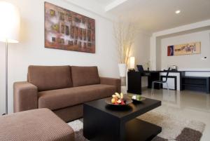ASTON Denpasar Hotel & Convention في دينباسار: غرفة معيشة مع أريكة وطاولة