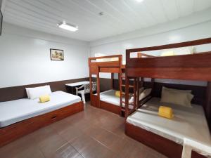 Zimmer mit 2 Etagenbetten und einem Schreibtisch in der Unterkunft Pacific Waves Inn (Annex) in Baler