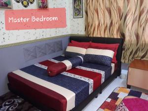Kampong Pantai HalbanにあるTSA Jitra Homestayのベッドルーム1室(カラフルな毛布と枕付きのベッド1台付)