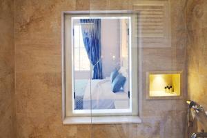 a bathroom with a window with a bed in it at Vinifera Ephesus Hotel in Selcuk