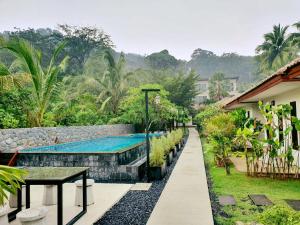 a resort with a swimming pool and a table at Laemsai Resort in Thalang
