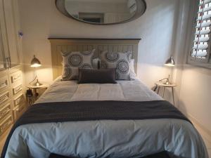 een slaapkamer met een groot bed en een grote spiegel bij La-Perna Guesthouse and Venue in Pretoria