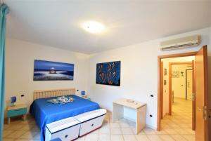 a bedroom with a blue bed and a table at La Risacca in San Vincenzo