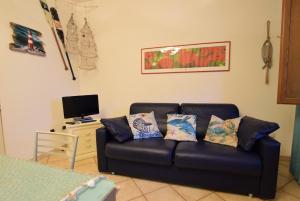 a living room with a couch and a tv at La Risacca in San Vincenzo