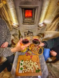 un groupe de personnes assises à une table avec des verres à vin dans l'établissement Maccan Cave Hotel, à Gorëme