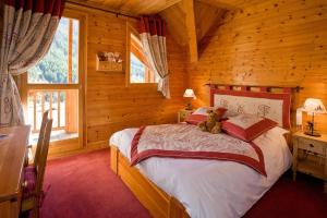 a bedroom with a bed with a teddy bear on it at Le Chalet d'en Hô in Névache