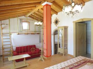Habitación con sofá rojo y lámpara de araña. en Agriturismo Villa Stella, en Rivoli Veronese