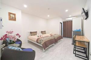1 dormitorio con 1 cama, mesa y sillas en Parvena Ratchada en Bangkok