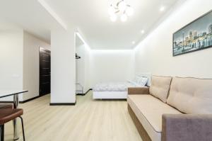 a white living room with a couch and a bed at ARTAL Apartment on Obolonsky avenue 31 in Kyiv