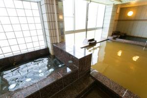 un bagno con ampia vasca e acqua di The Gran Resort Arima a Kobe