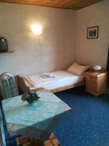 弗里茨拉的住宿－Reit- und Ferienhof Emstal，小房间设有床和玻璃桌