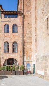 - un grand bâtiment en briques avec une grande fenêtre dans l'établissement Casa del Campanaro centro storico di Lucca dentro le mura, à Lucques