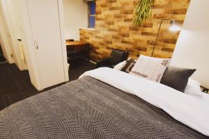 sypialnia z łóżkiem i ceglaną ścianą w obiekcie Tune Inn Tokyo Bay w Tokio