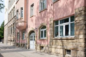 a pink building with windows on a street at Ferienwohnung City in Erfurt