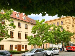 grupa samochodów zaparkowanych przed budynkiem w obiekcie Golden Wood Apartments w Pilznie