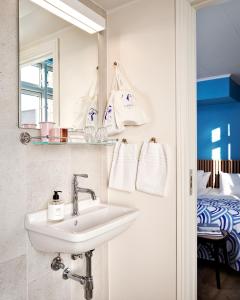 a bathroom with a sink and a mirror and a bed at Coco Hotel in Copenhagen