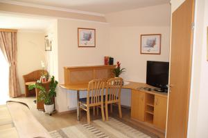 ein Wohnzimmer mit einem Schreibtisch und einem TV in der Unterkunft Hotel Lang in Leibnitz