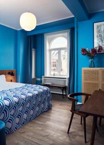 Coco Hotel في كوبنهاغن: غرفة نوم بجدران زرقاء وسرير وطاولة