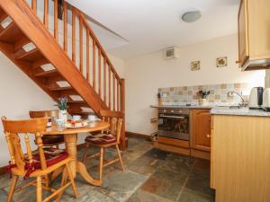 a kitchen with a wooden table and a staircase at The Wagon House in Launceston