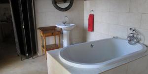 a bathroom with a bath tub and a sink at Waterberg Accommodation in Modimolle