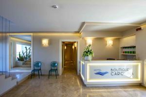 馬里納－迪卡斯塔涅托的住宿－Hotel Boutique Carolina，大堂设有柜台和2把蓝色椅子