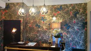 a room with a wall with a peacock wallpaper at Hotel Relais Du Postillon in Antibes